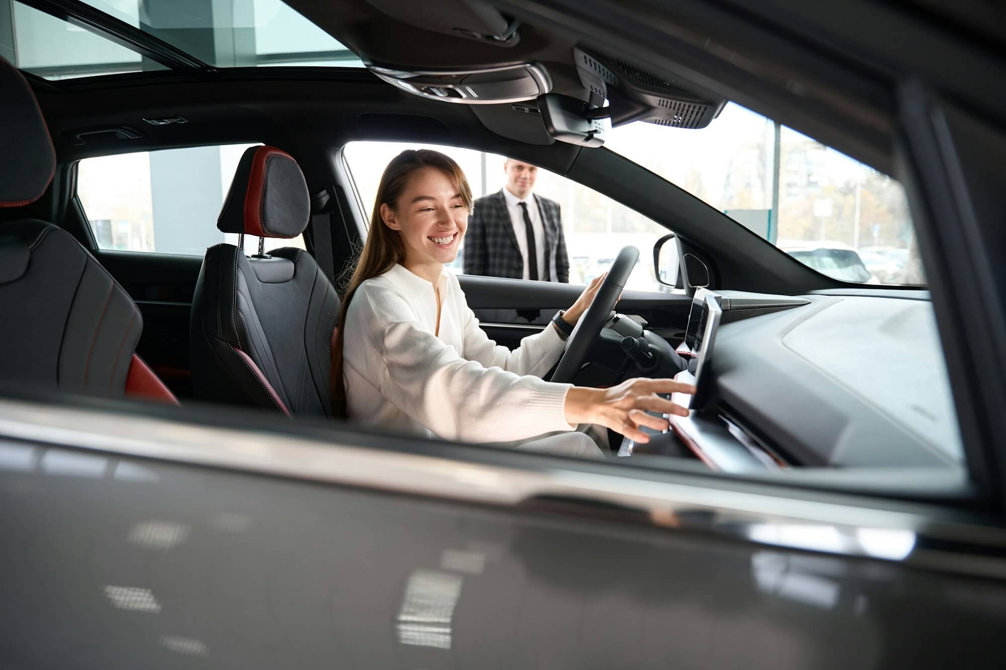 woman-choosing-new-car-in-dealership-with-salesman-trying-on-new-automobile.jpg